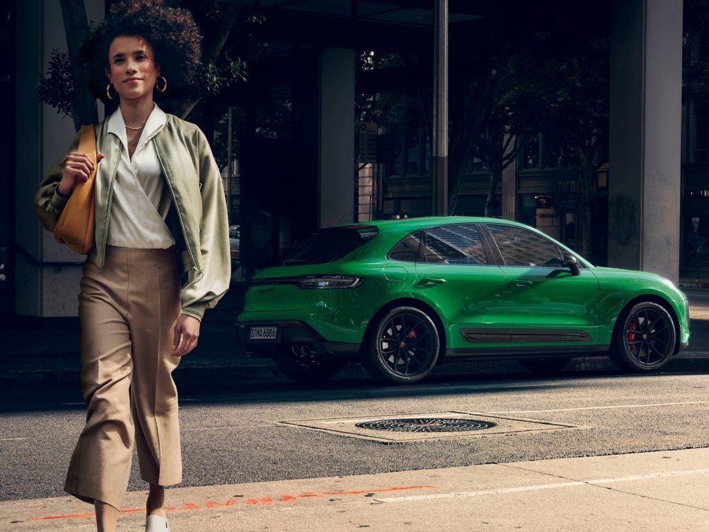 Driver enjoying the 2026 Porsche Macan GTS on the open road, blending performance and refinement.
