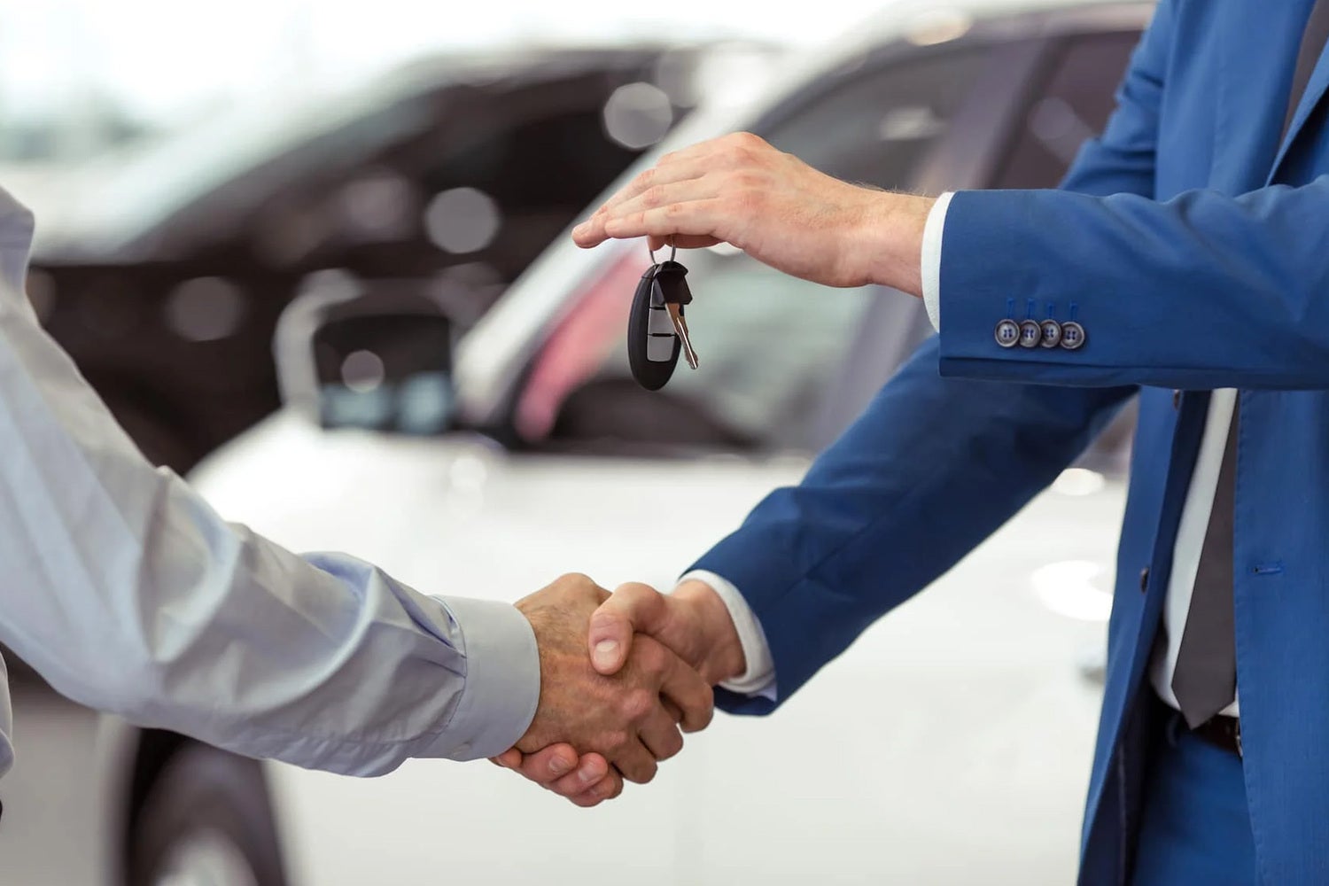 Finance Center Team member handing over the keys to a customer while shaking hands