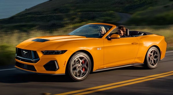 Orange Ford Mustang Convertible Driving Down a Road