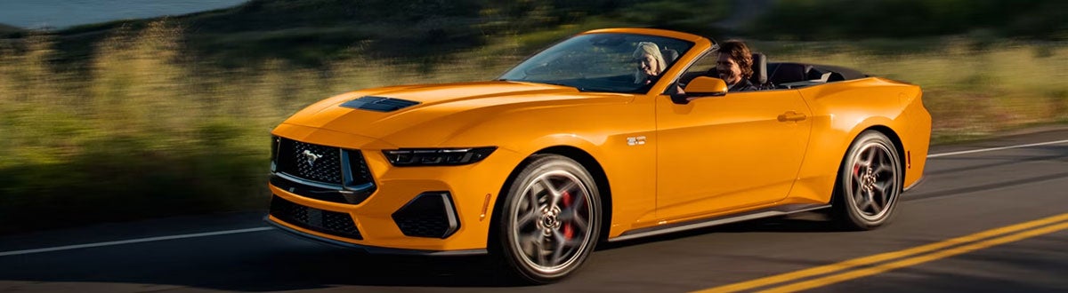 Orange Ford Mustang Convertible Driving Down a Road