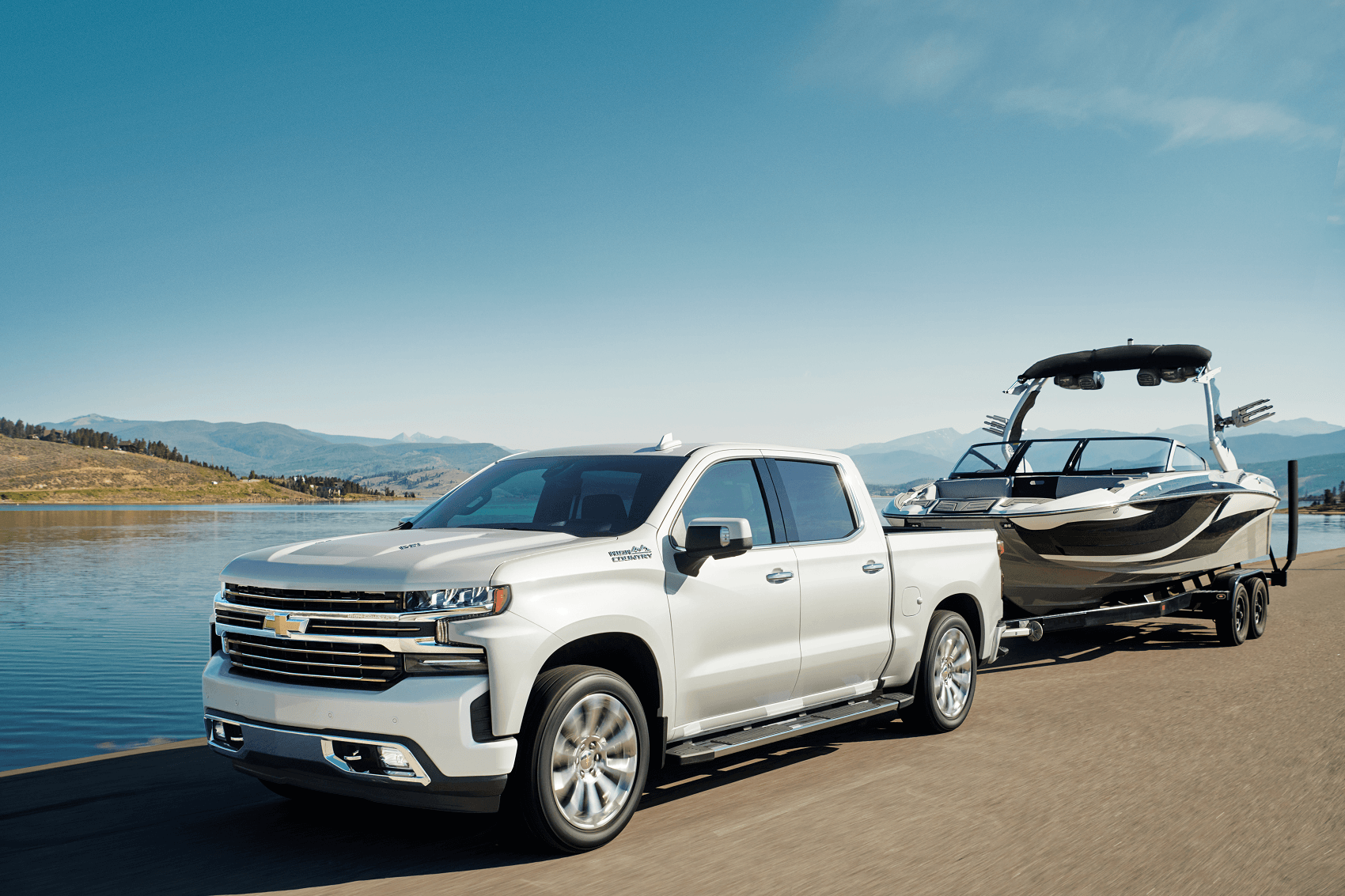 White 2021 Chevy Silverado 1500 towing white boat