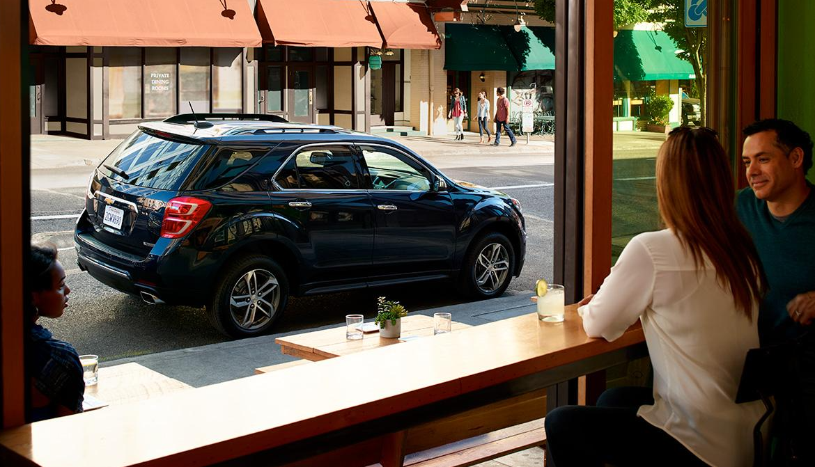 View of Chevrolet Equinox parked on the street outside of cafe from Used Car Dealer in Fridley MN