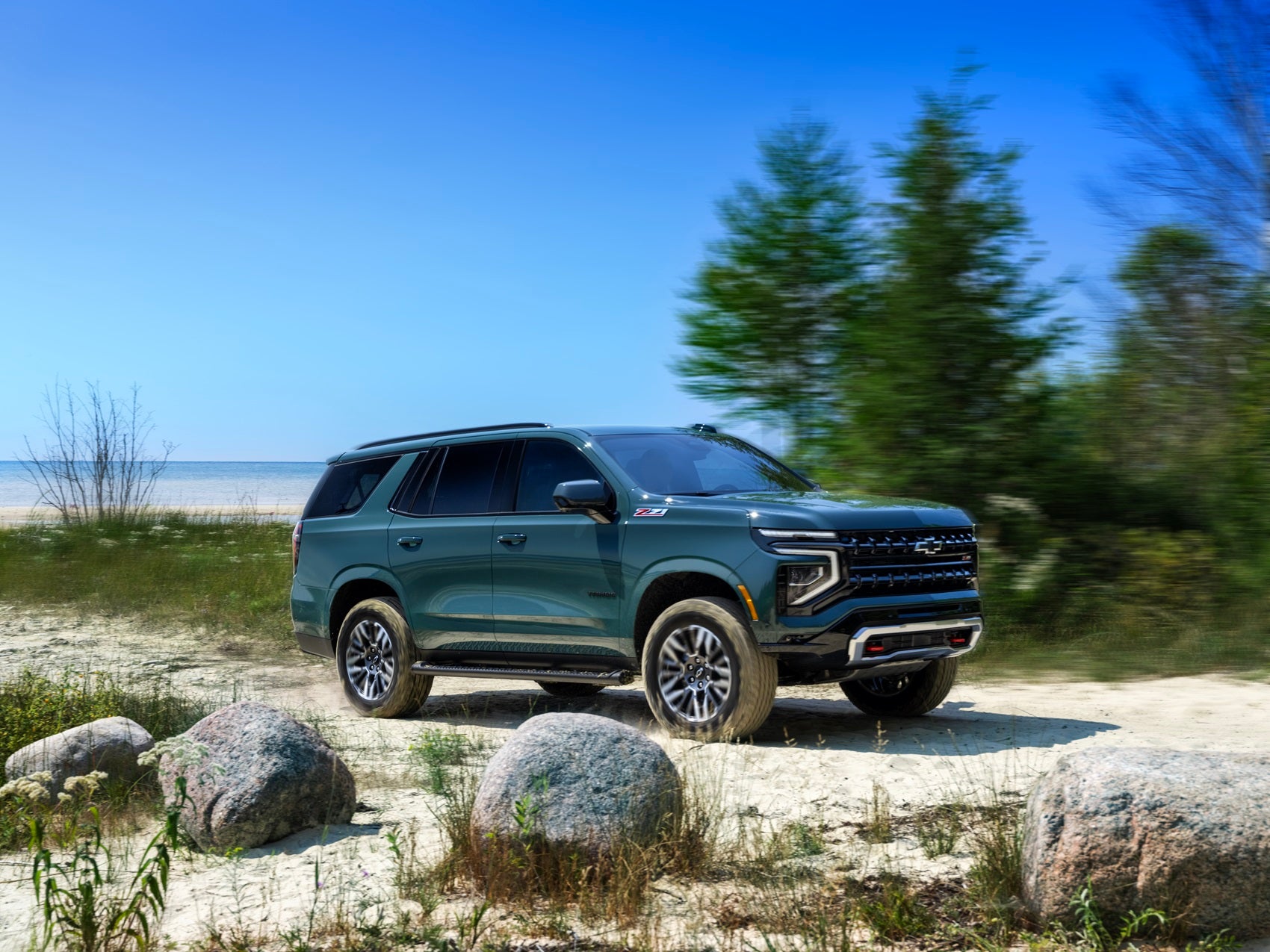 Chevrolet Tahoe parked by the water in the sand