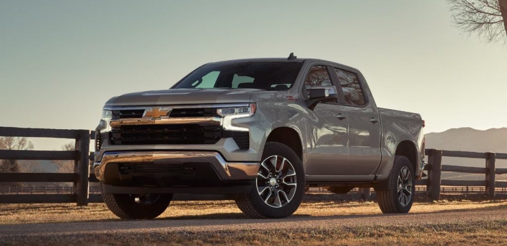 A new Chevy Silverado truck sits parked on a dirt road with a farm fence behind it. Shop for your new Chevy Silverado at Morristown Chevrolet today!