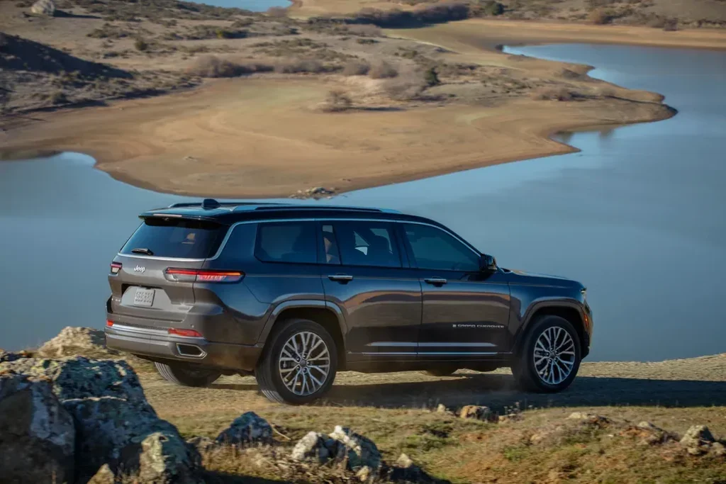 Jeep Grand Cherokee L Parked 3/4 Rear View on a Cliff Overlooking a Lake