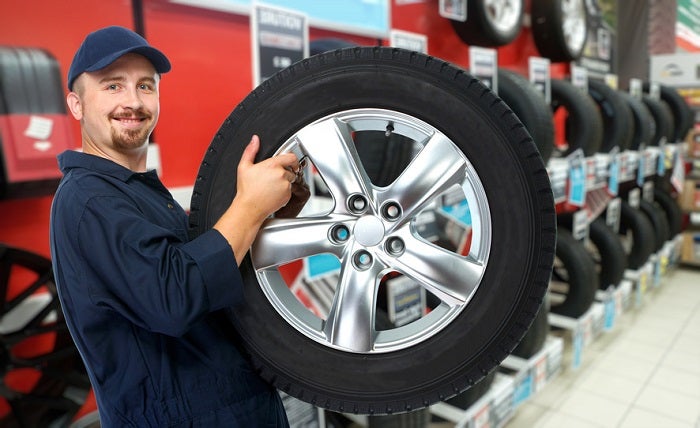 Car mechanic with a tire.