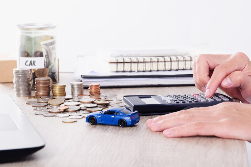 A person calculating their car payment.