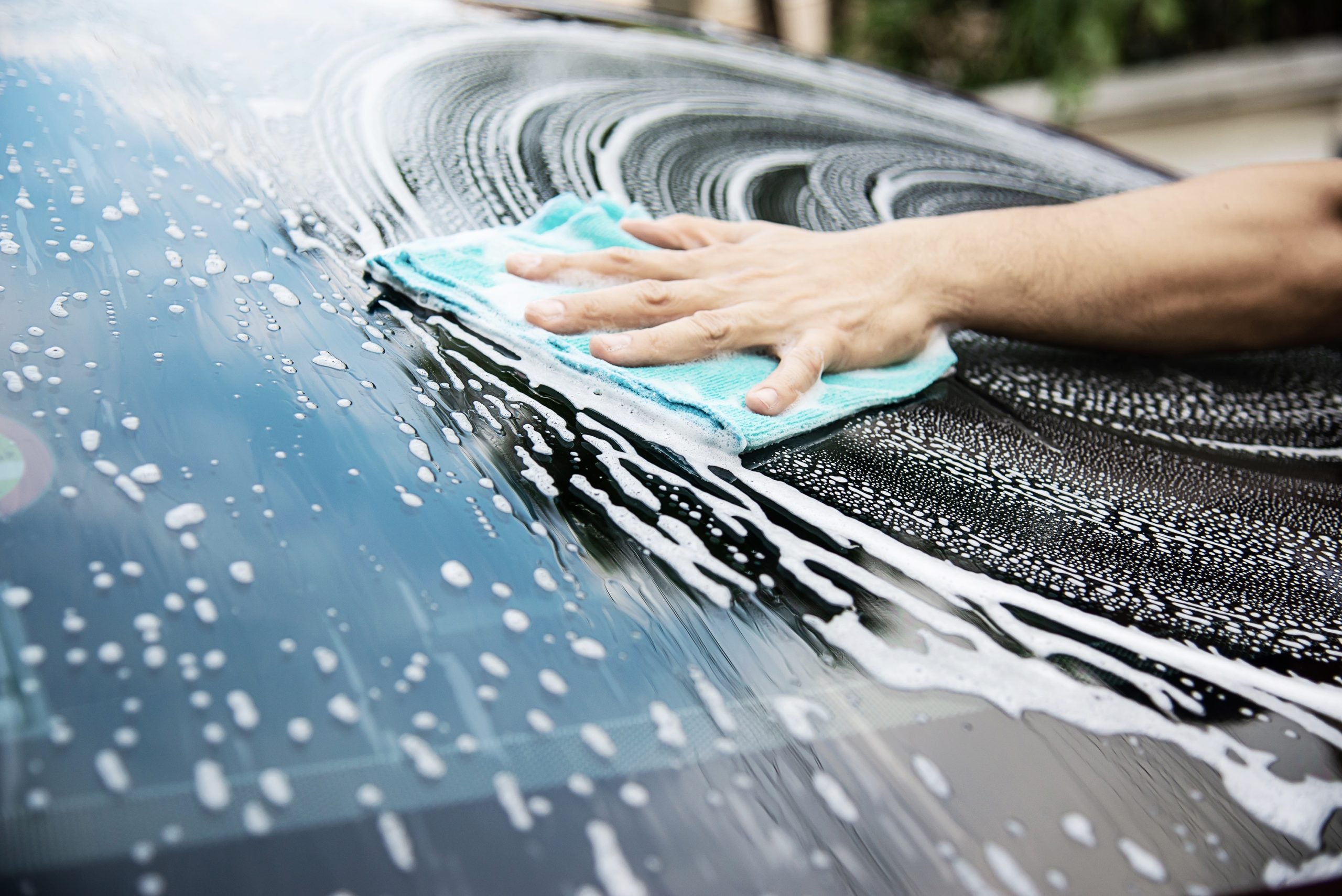 Man wash car using shampoo - every day life car care concept
