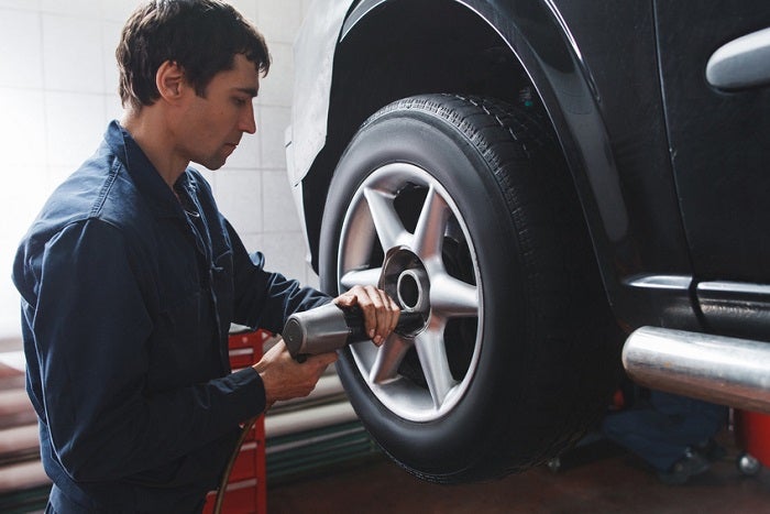 Mechanic changing car wheel in auto repair shop