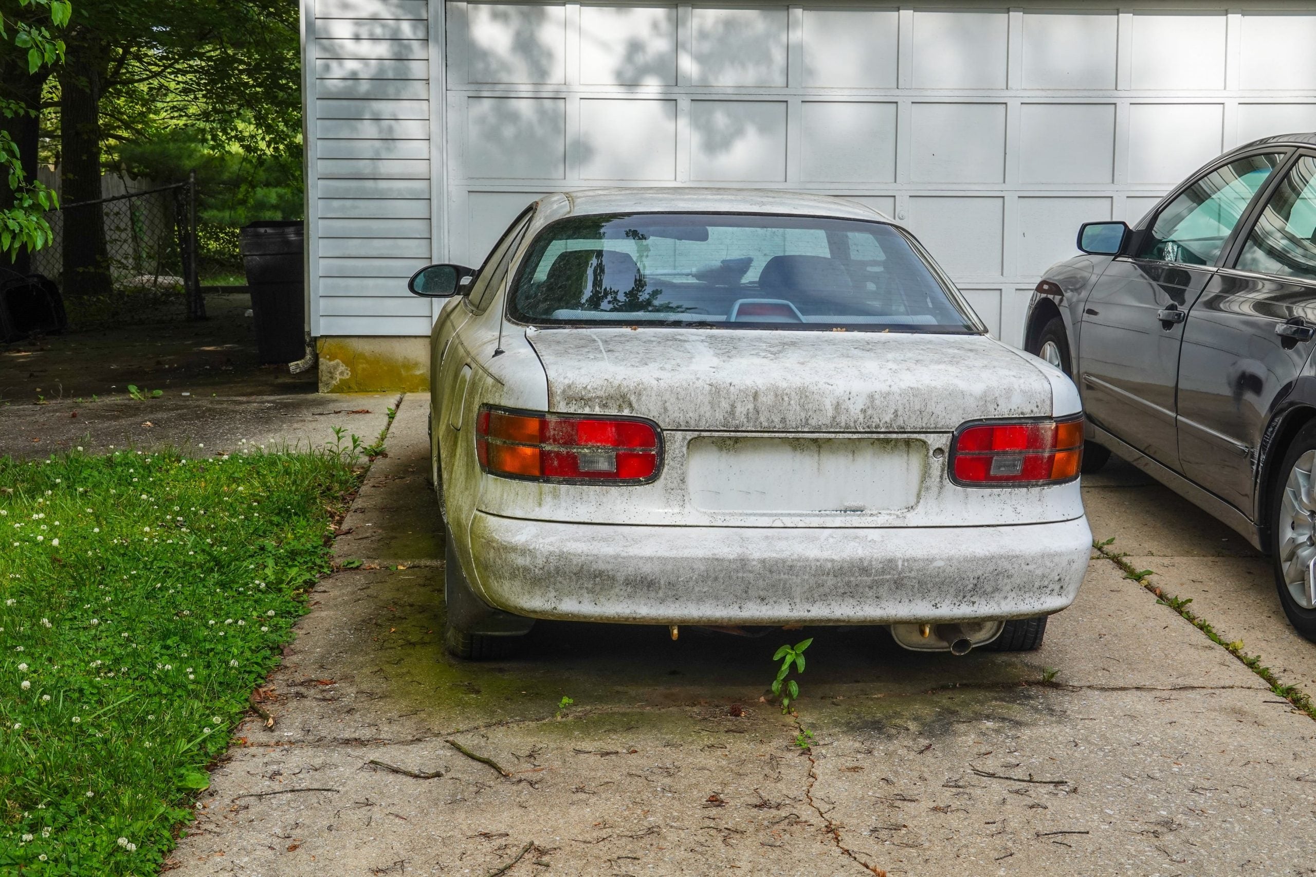 Older Used car parked in front of a garage