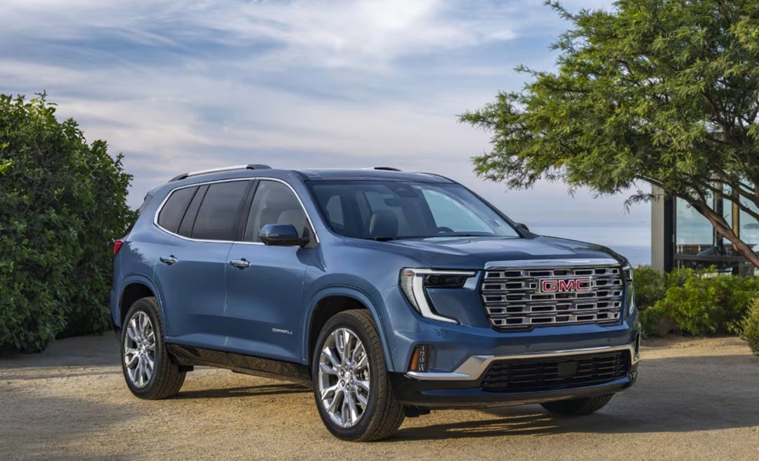 2025 GMC Acadia SUV exterior parked in front of the ocean in blue