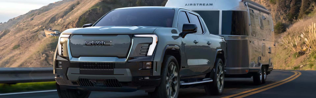 Gray Sierra EV driving on mountain road