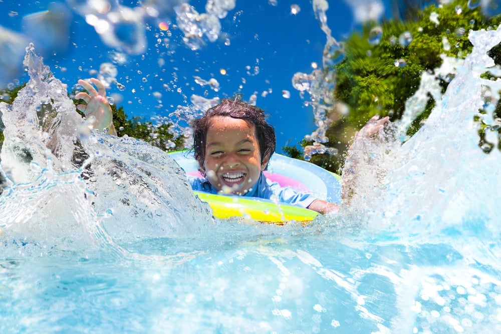 A photo of a child splashing in a swimming pool