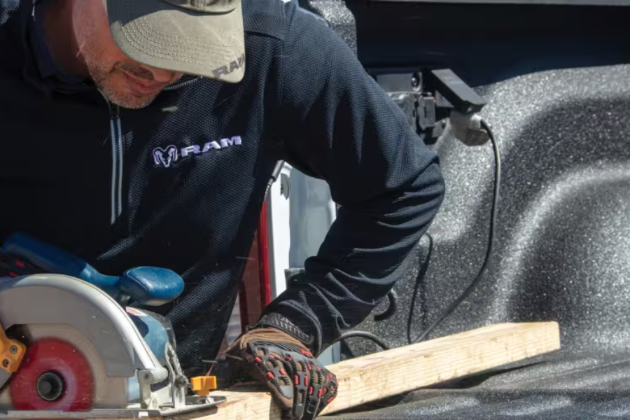 Worker using an available Ram 2500 onboard power outlet to operate a saw