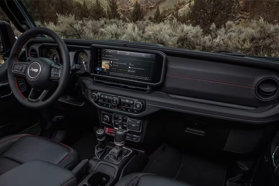 View of the Jeep Wrangler interior, dashboard, seating, and open roof