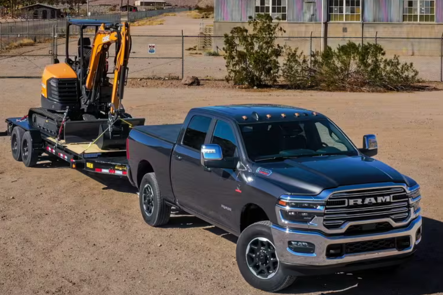 Ram 2500 Heavy Duty truck towing construction equipment on a flatbed trailer