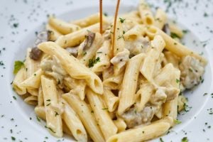 A bowl of fettuccine garnished with parsley.