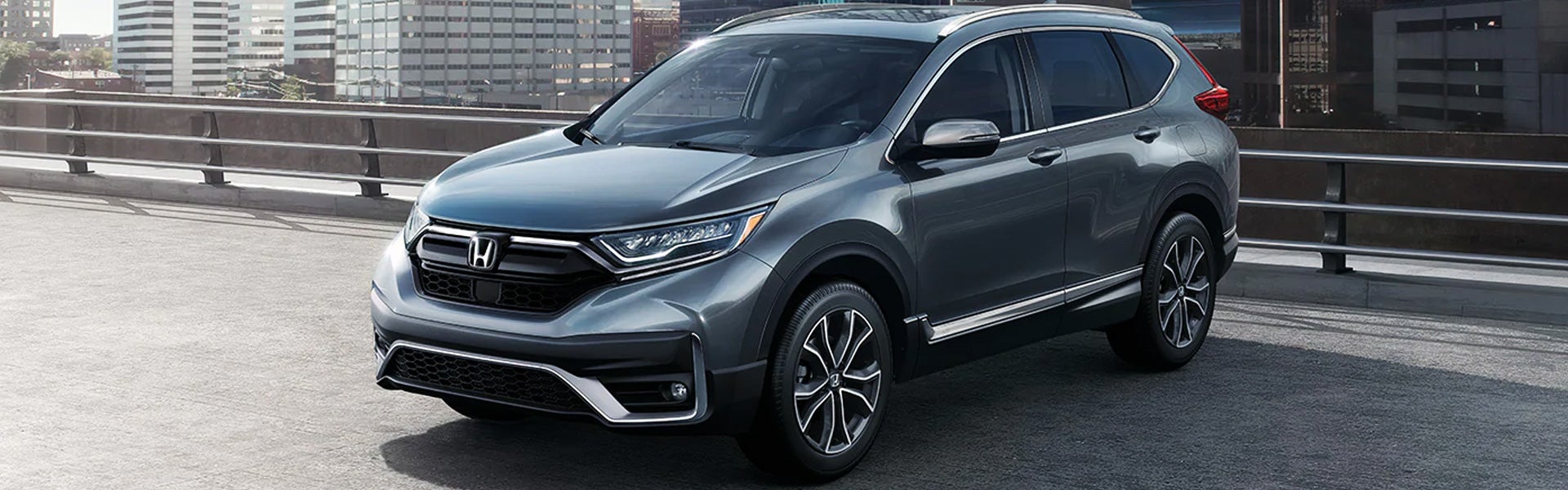 Gray Honda CR-V SUV parked on urban bridge, showcasing sleek design and modern styling | Priority Honda Roanoke