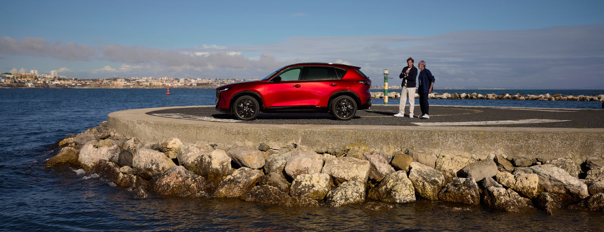 2026 Mazda CX-5 in Soul Red parked on a rocky coastline