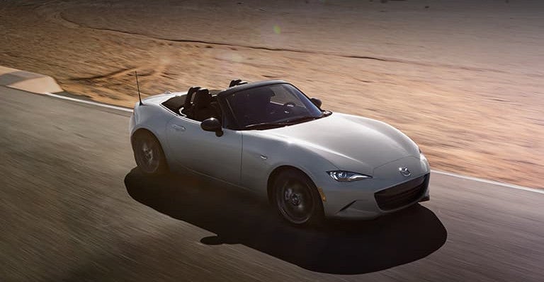 Mazda MX-5 Miata soft top roadster with the roof down, front three-quarter view