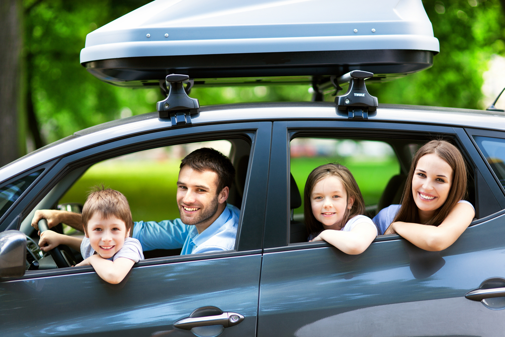 a family of 4 inside a car looking out the windows