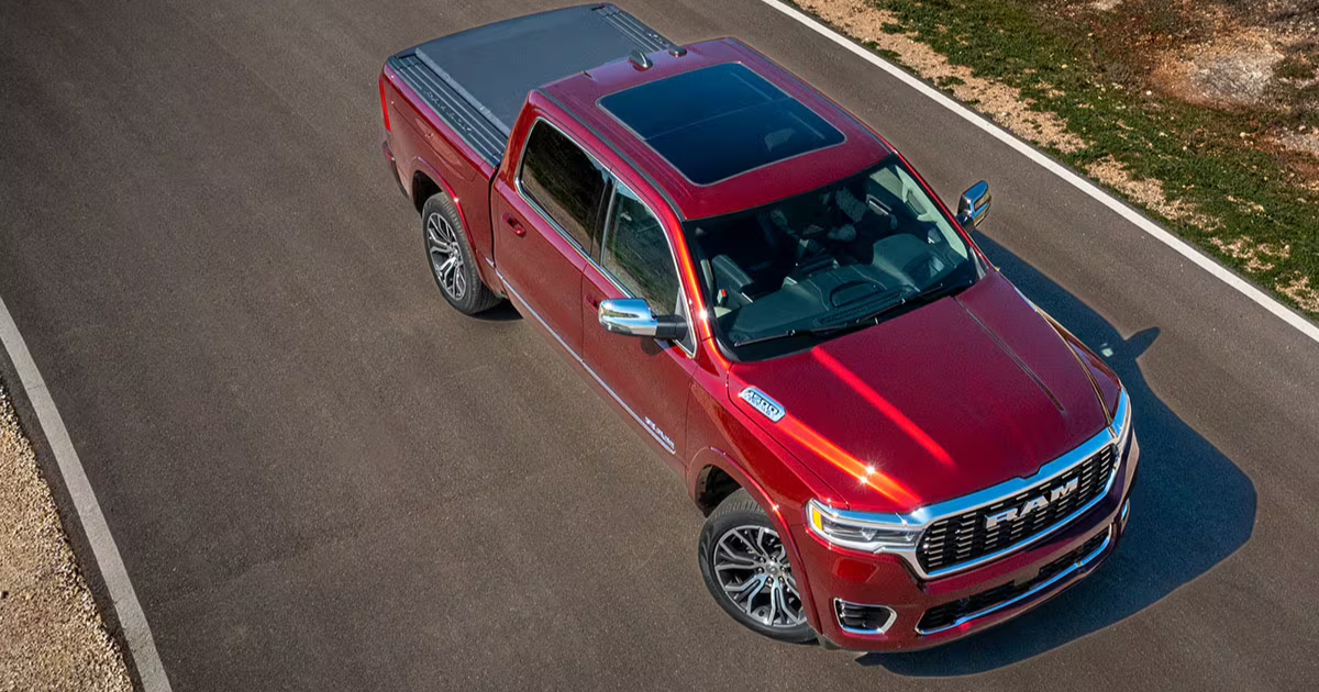 An aerial view of a red Ram 1500 driving down a road.