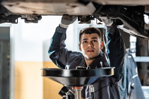 Auto technician changing oil