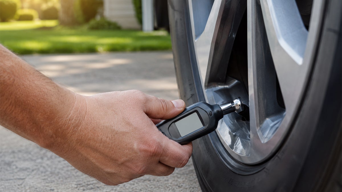 Tire gauge measuring tire pressure on a car tire