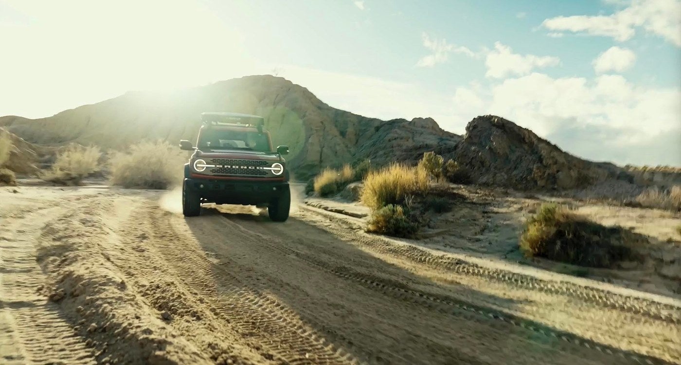 Ford Bronco driving a dirt trail through dry hills, a trail ready SUV for Clay Center, Kansas drivers
