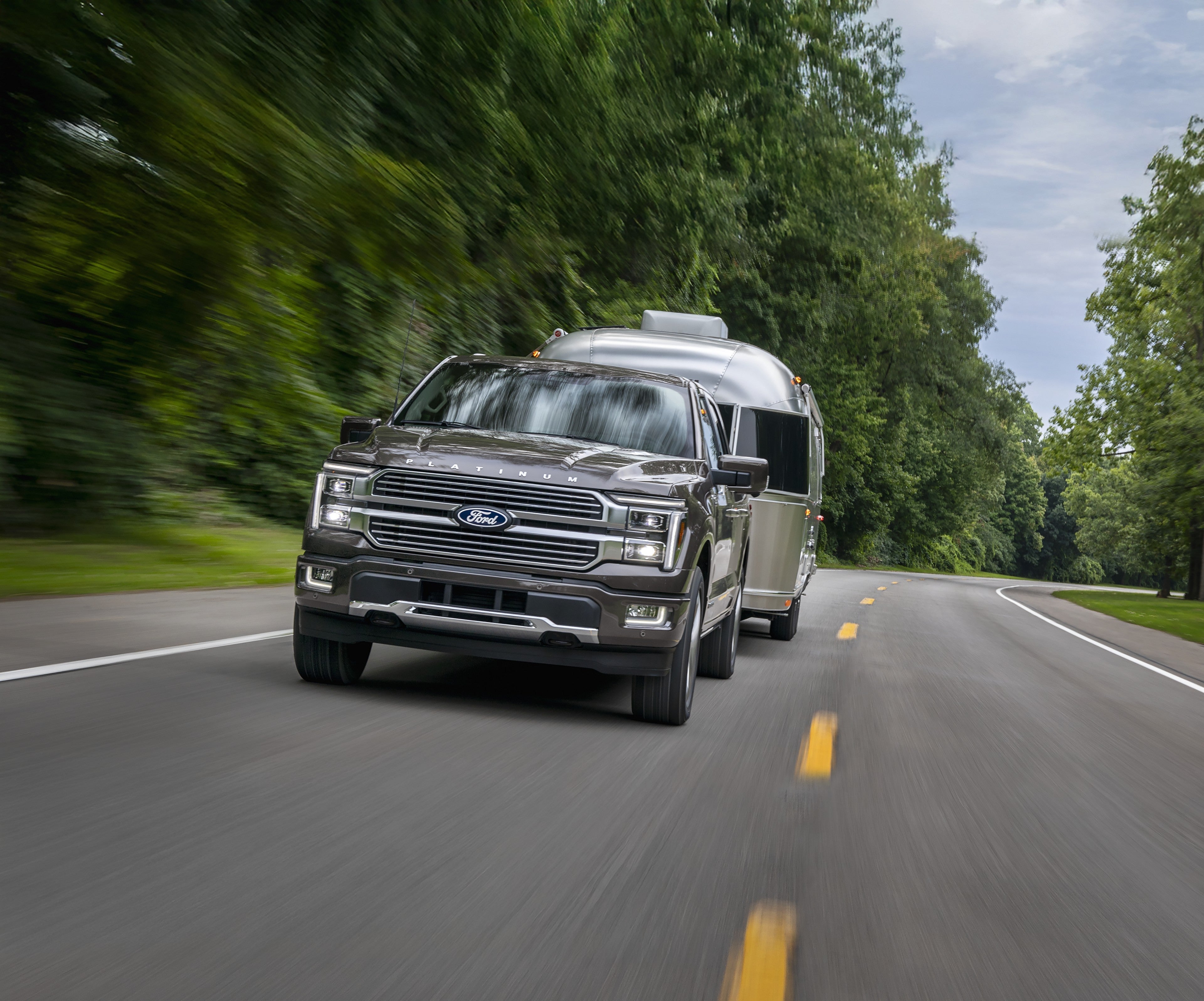 2026 Ford F-150 Platinum in Marsh Gray pulling a camper