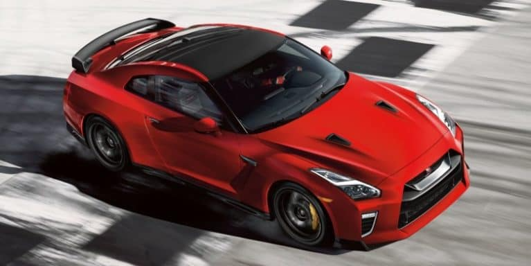 A red 2021 GT-R drives down a road