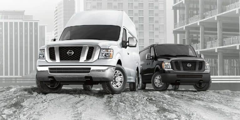 A white and a black 2021 nv cargos parked in a construction site.