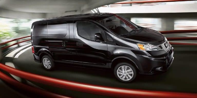 A 2021 Nissan NV drives up a parking garage ramp.