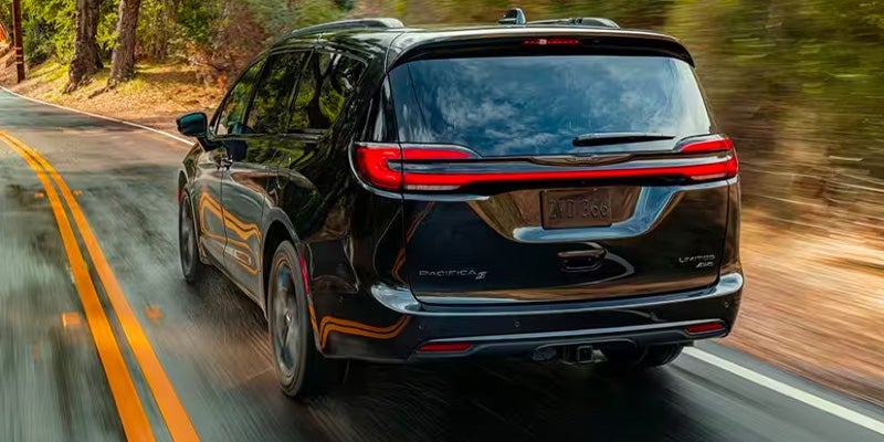 A black chrysler pacifica driving in the rain