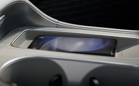 A smartphone resting on the wireless charging pad in the Palisade center console