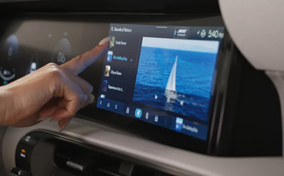 A finger tapping the Palisade 12.3-inch touchscreen showing a sailboat image