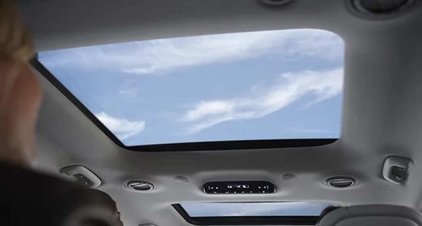 Blue sky and clouds seen through the open dual pane sunroof of the Palisade