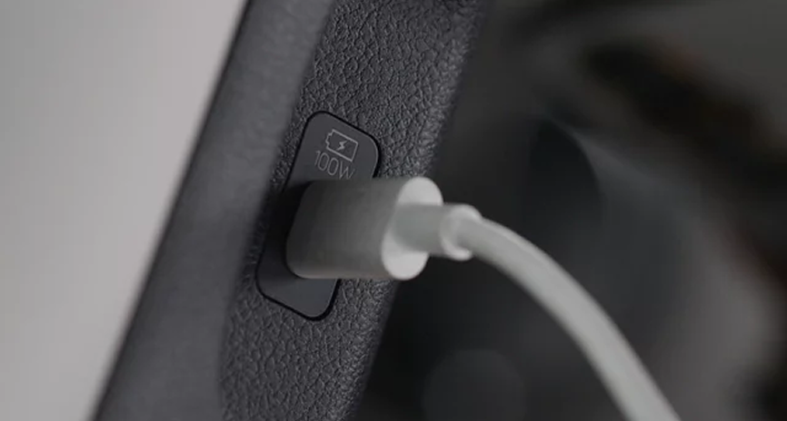 A white charging cable plugged into a USB-C port in the Palisade cabin