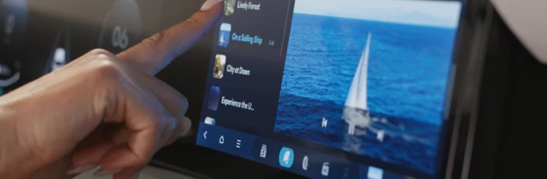 A finger tapping the Palisade touchscreen displaying a sailboat on the ocean