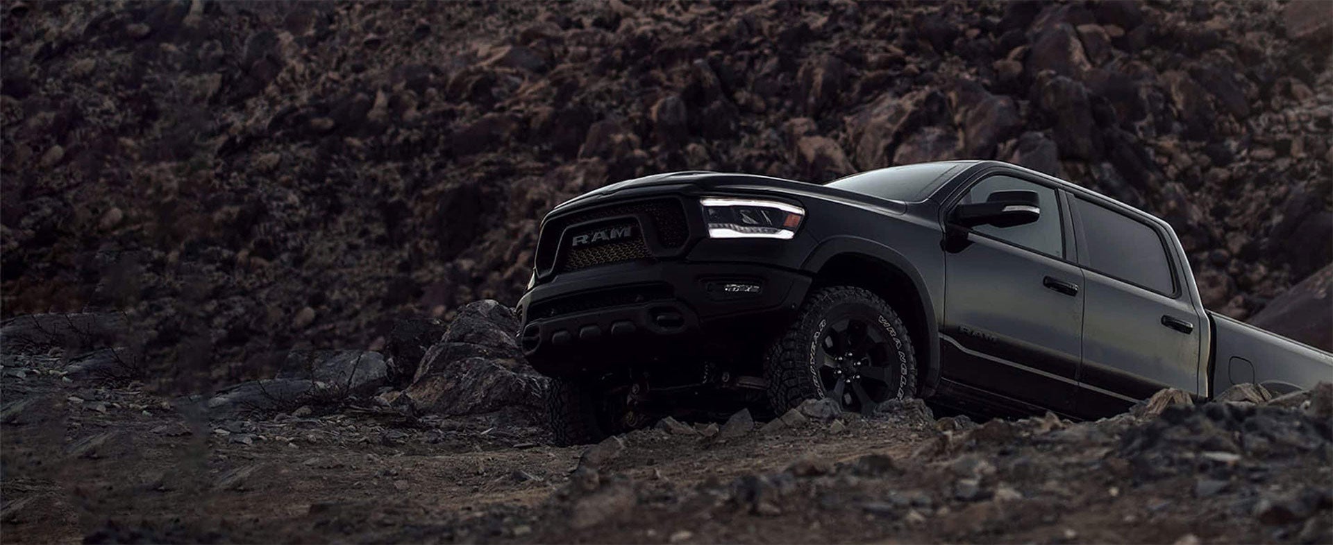 A blacked out Dodge Ram 1500 truck climbing uphill