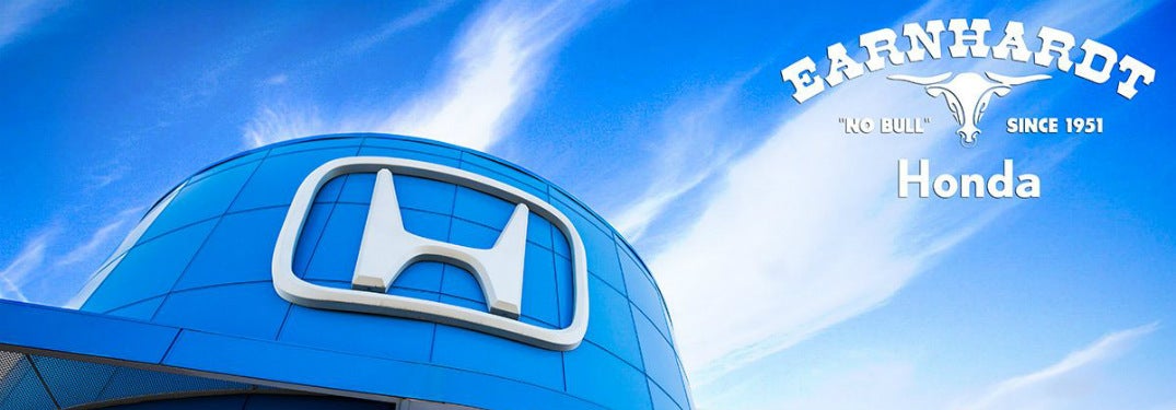 View of the tip of the dealership roof with a big Honda logo on it and the sky beyond. White text in the upper-right reads "Earnhardt Honda 'No Bull' Since 1951"