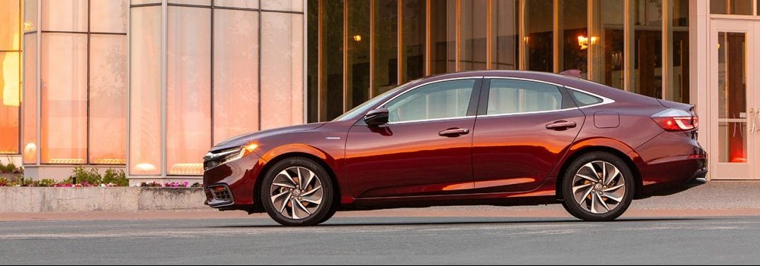 Crimson Pearl 2020 Honda Insight parked outside a building and viewed from the side at sunset.