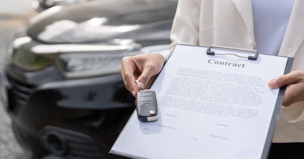 Dalton Subaru car dealer presenting a customer a lease contract and car key