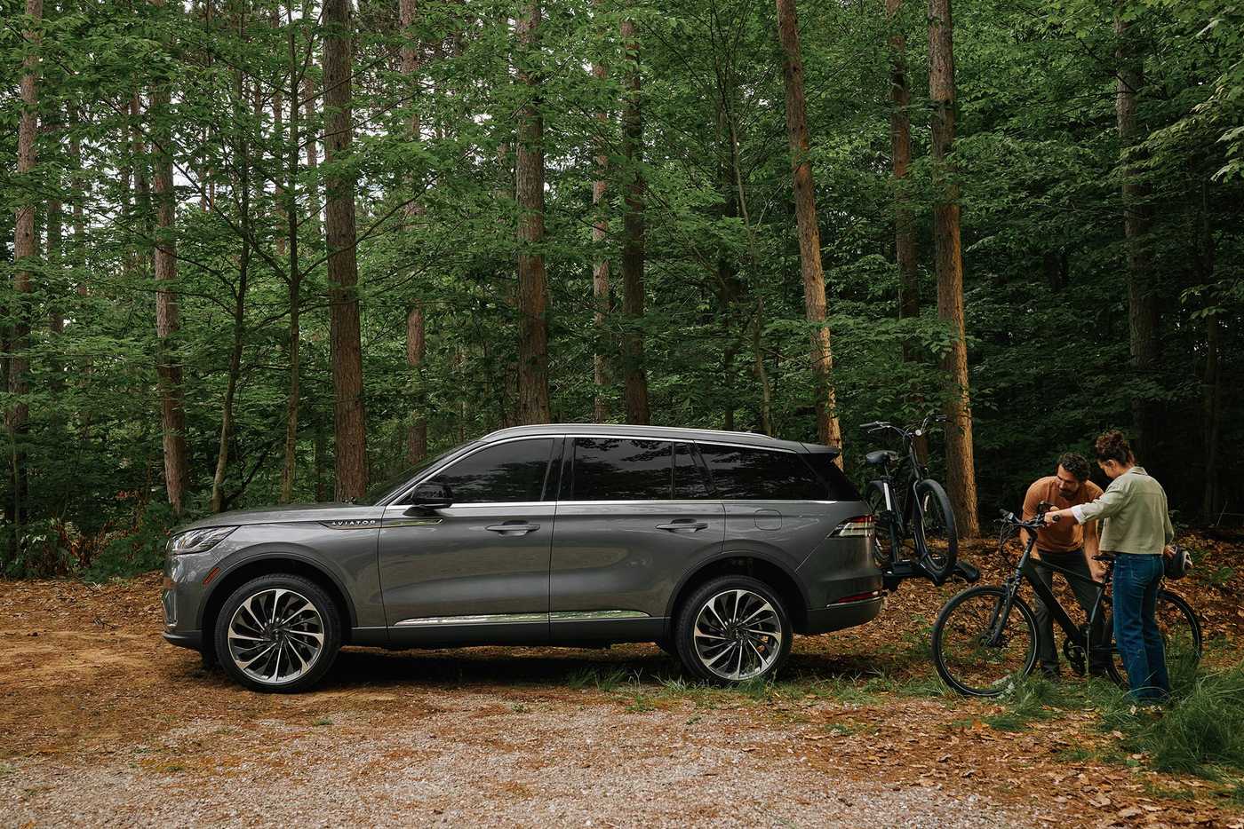 Father and son loading bicycles onto a rack on a gray Lincoln Aviator Father and son loading bicycles onto a rack on a gray Lincoln Aviator