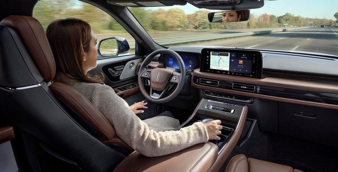 Woman driving a Lincoln Aviator hands free with BlueCruise while keeping her eyes on the road Woman driving a Lincoln Aviator hands free with BlueCruise while keeping her eyes on the road