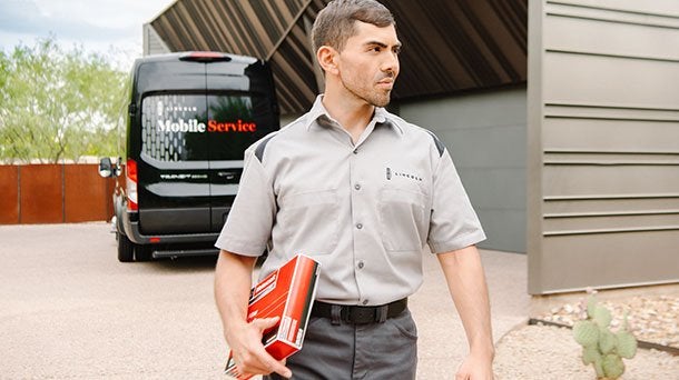 Lincoln Mobile Service technician walking from the service van to a client home Lincoln Mobile Service technician walking from the service van to a client home