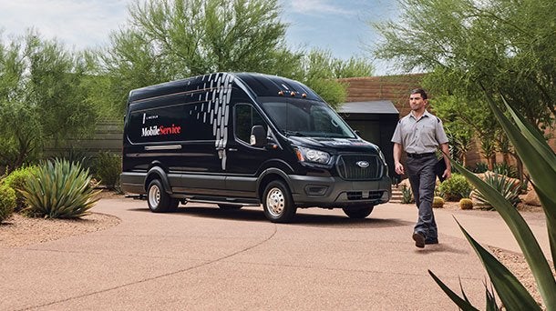 Lincoln Mobile Service van parked in a home driveway as the technician walks up Lincoln Mobile Service van parked in a home driveway as the technician walks up