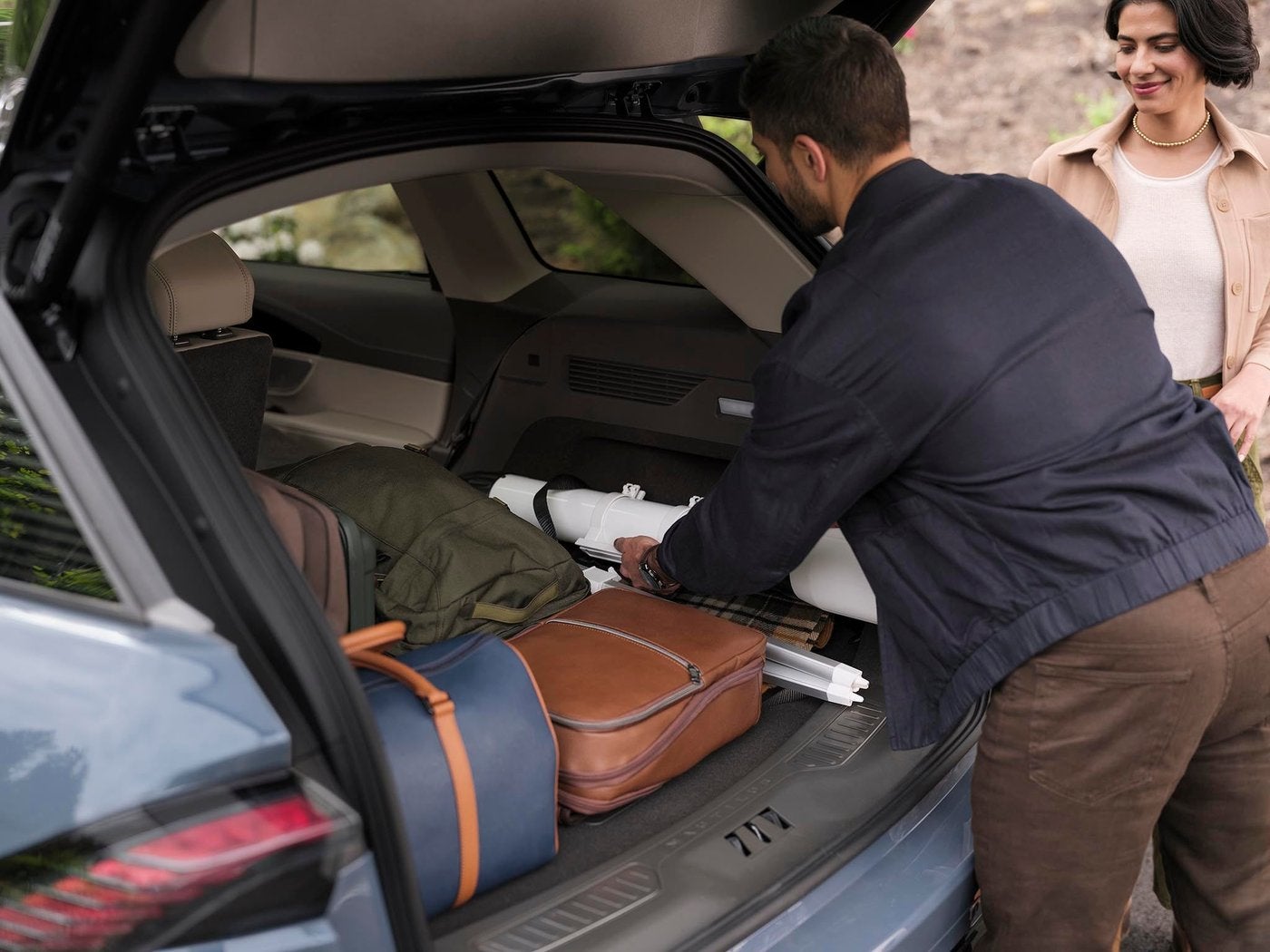 Man loading luggage into the cargo area of a Lincoln Nautilus with the rear seat folded