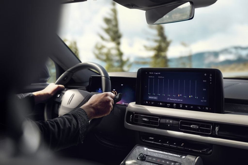 Shoulder down view of male driver grasping the steering wheel of 2026 Lincoln Aviator