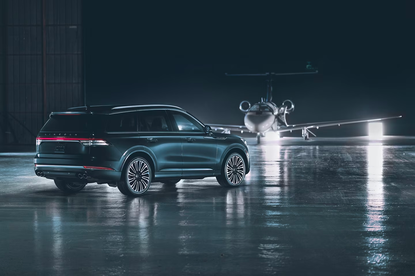 black lincoln aviator in front of a plane